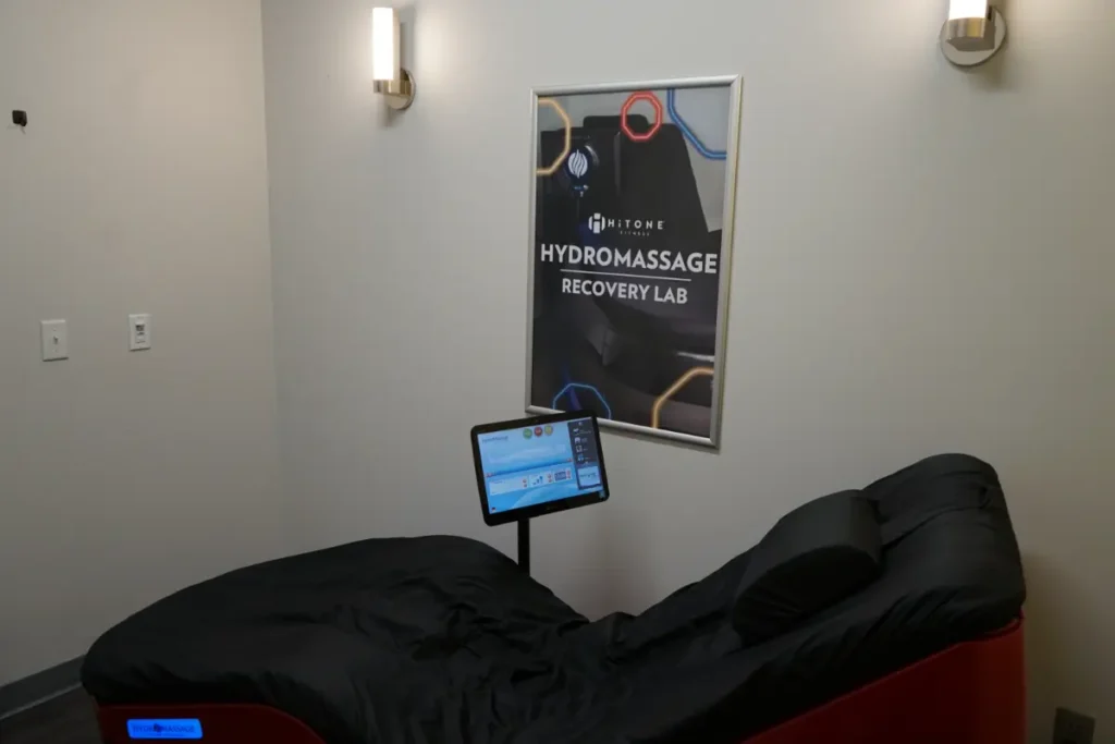 A hydro massage chair, next to a hitone poster.