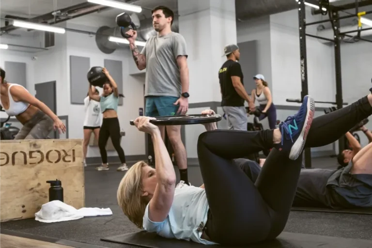 A woman laying down holding a light plate, doing an exercise.