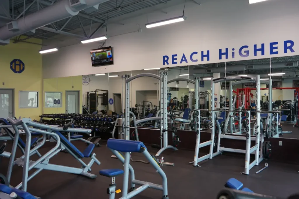 Two gym racks, in front of mirrors.