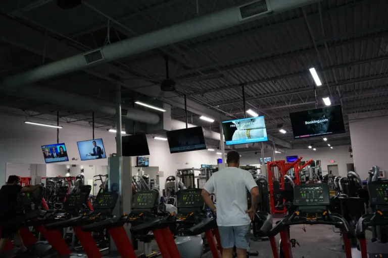 Set of treadmills, a man is standing on one.