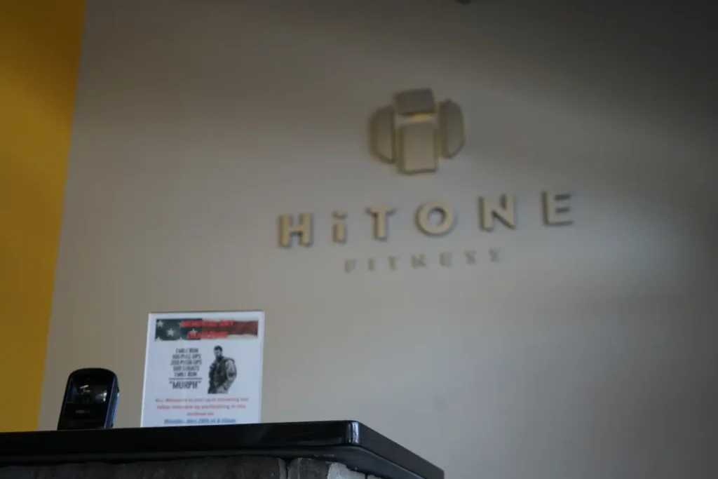 A gray wall with a Hitone Fitness logo.
