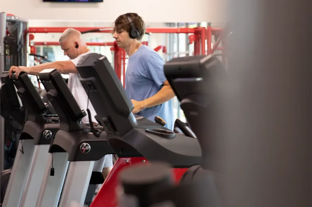 Two men working out on a treadmill.