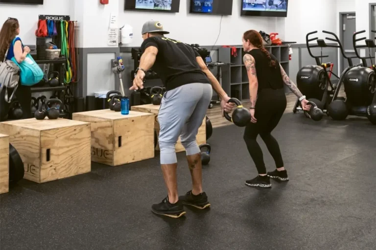 Man and Woman working out with a Cattle bell.