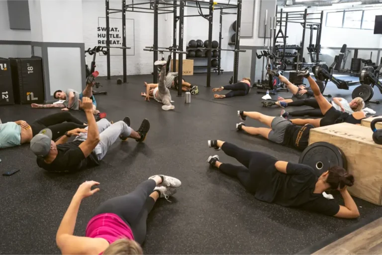 Gym goers stretching on the floor.