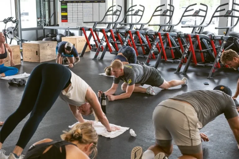 People stretching on the floor of a gym.