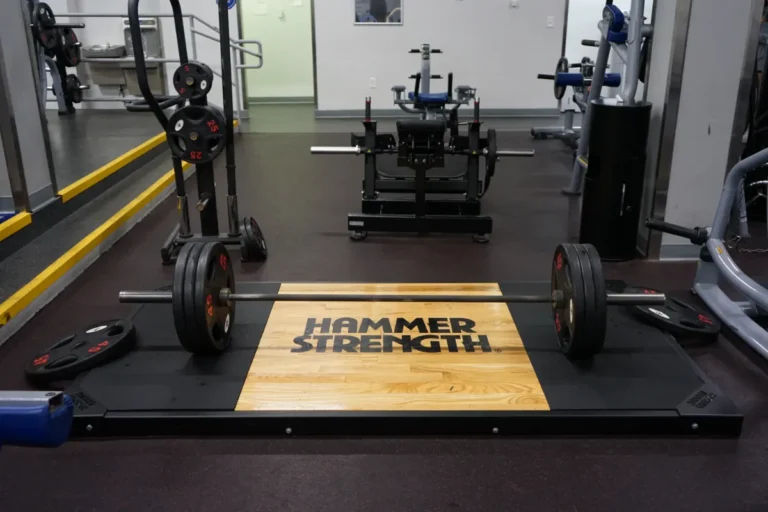 Weights next to a hammer strength mat.