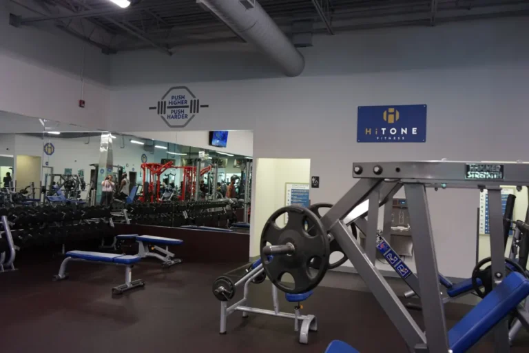 Hammer strength machine and a two flat benches at a gym.