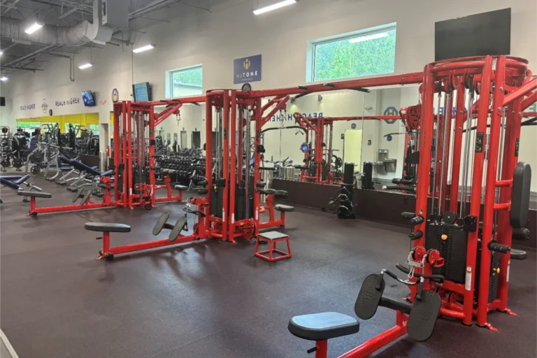 A red cable crossover machine at a gym.