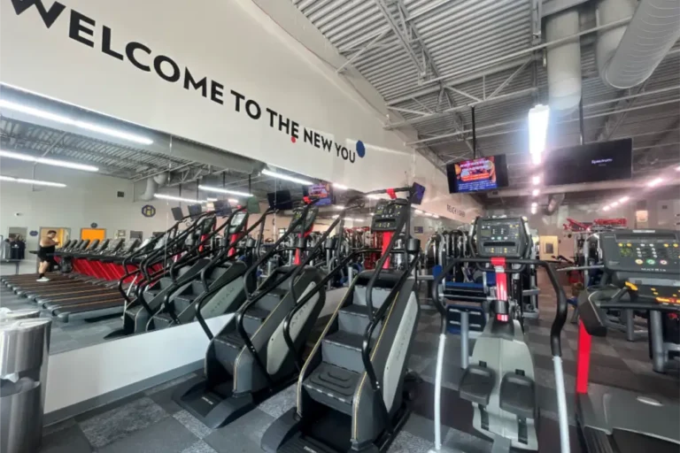 Two stair climbers and an elliptical trainer machine at a fitness center.