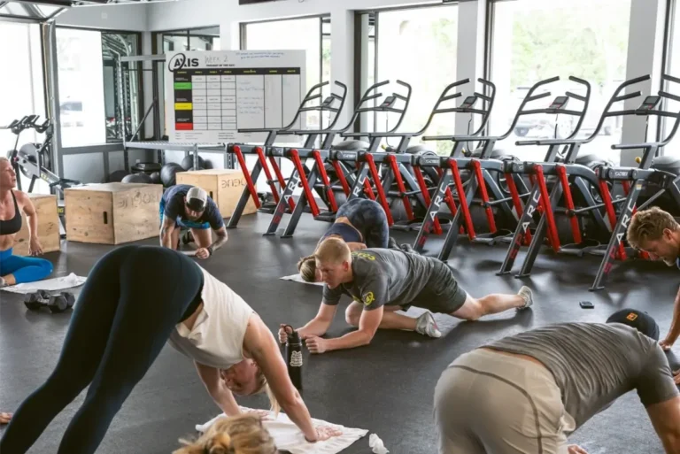 Seven people practicing yoga at a gym.