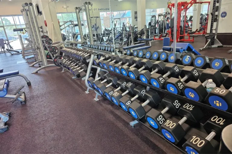 Weight racks and other exercise equipment at a gym.