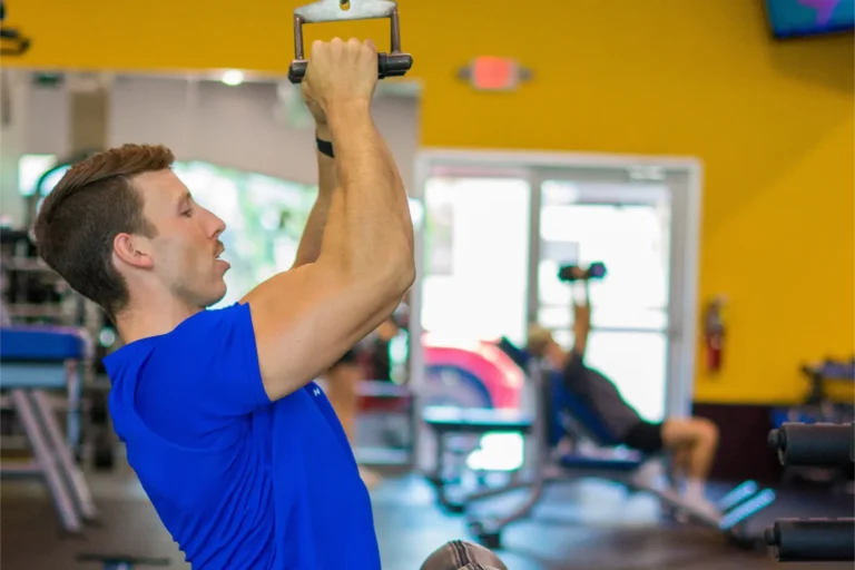 A man doing a pull-up exercise at a gym.