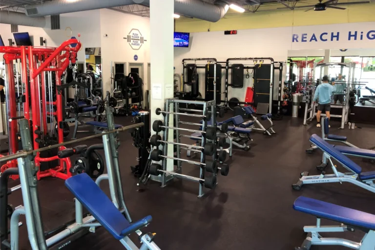 Various racks, benches, and exercise machines at a fitness center.