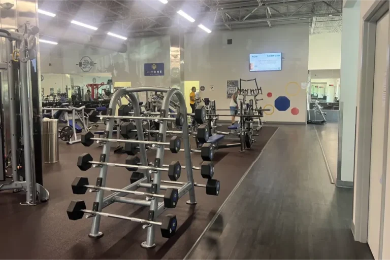 Fixed barbells on a weight rack at a gym.