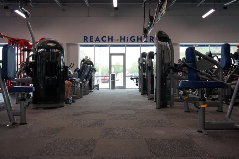 Carpeted floor and various exercise machines inside a gym.