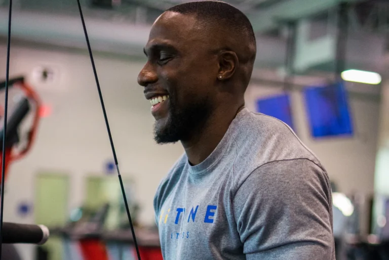 A short haired man in a gray t-shirt is smiling.