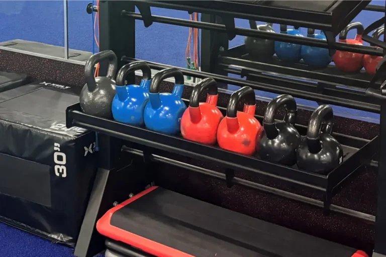 Seven kettlebells on a rack at a gym.