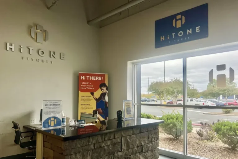 A reception desk with HiTONE fitness sign on the wall above it.