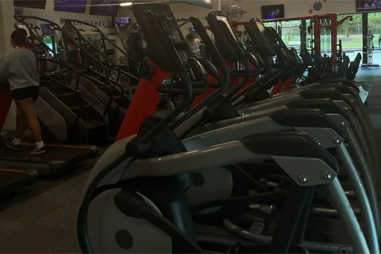 Treadmills at a gym. A person is exercising at one of them.