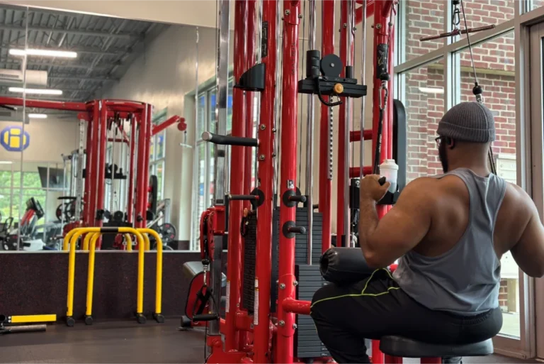 A man doing the seated lat pulldown exercise on the high pulley machine.