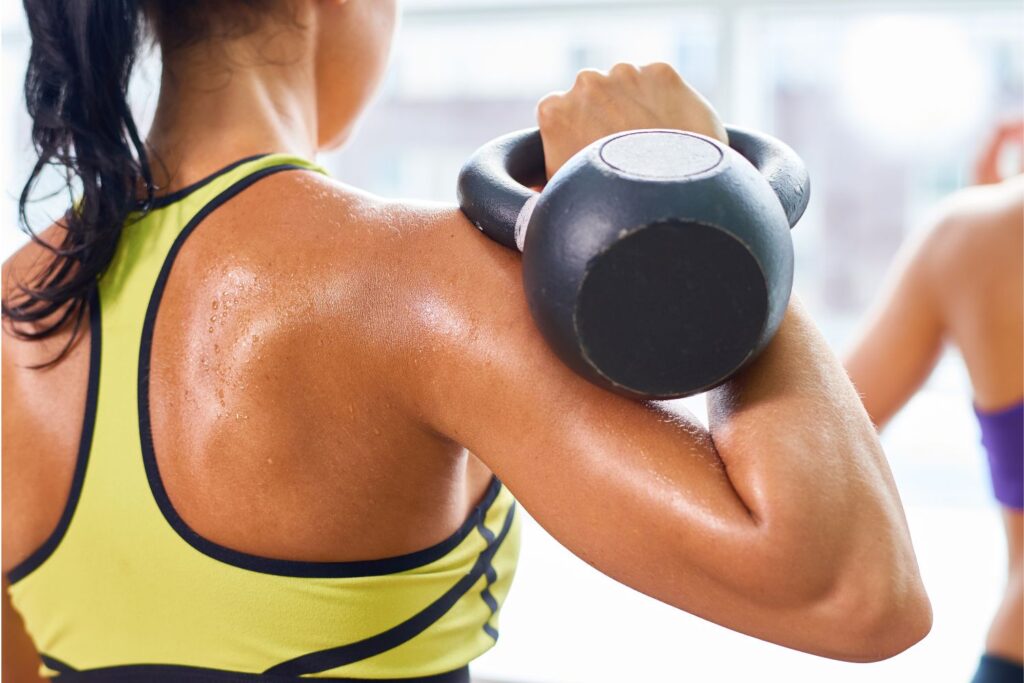 A woman performing the kettlebell rack position.