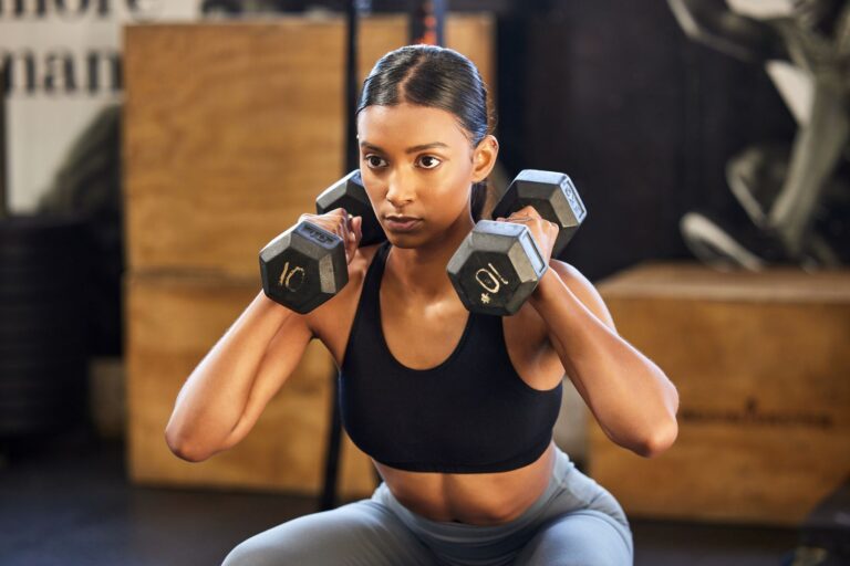 A woman doing a dumbbell front squat with 10-pound weights.