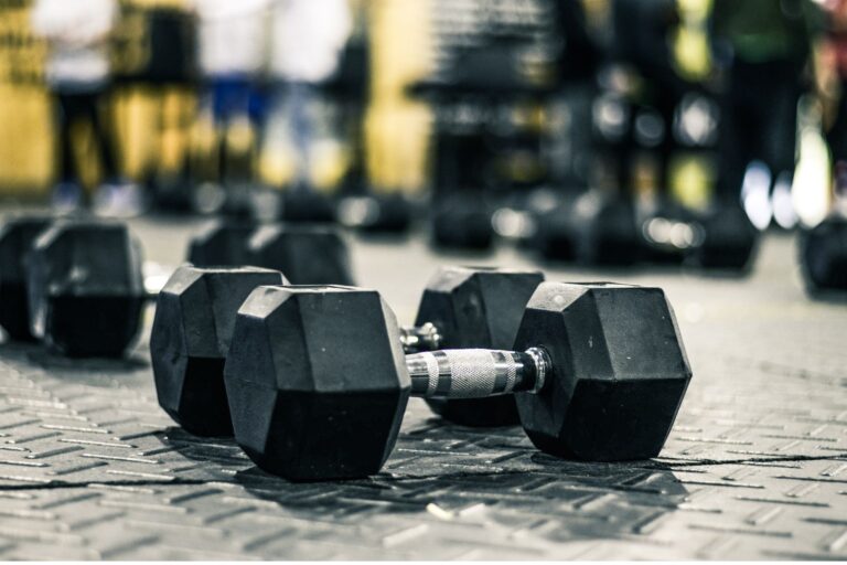 Hex dumbbells on the metal floor.