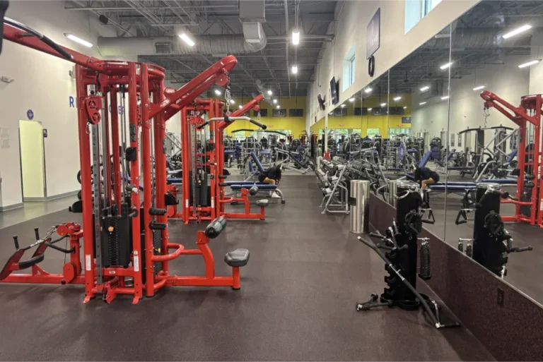 Two cable crossover machines in front of a mirror at a gym.